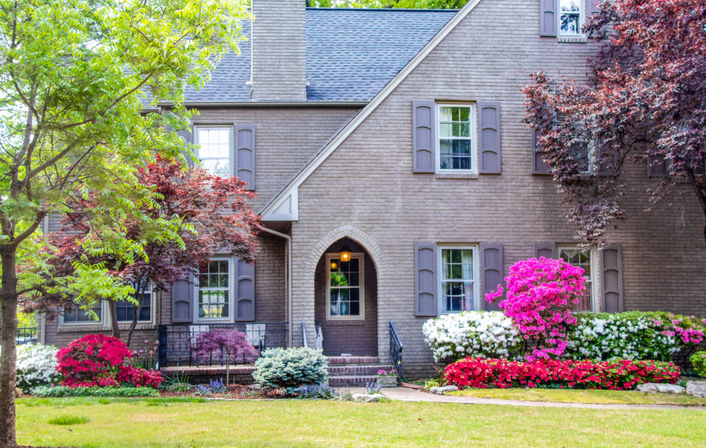 Brick two story house with Japanese Maples and Azaleas in front yard landscape