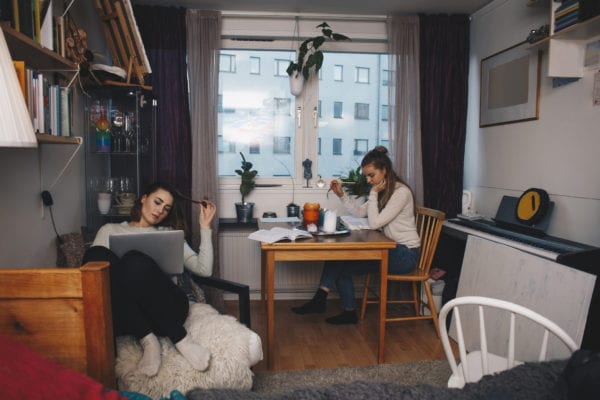 Girls studying in a room with curtains in the window