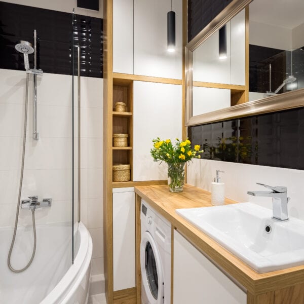 Black and white bathroom with shower and wooden cabinet