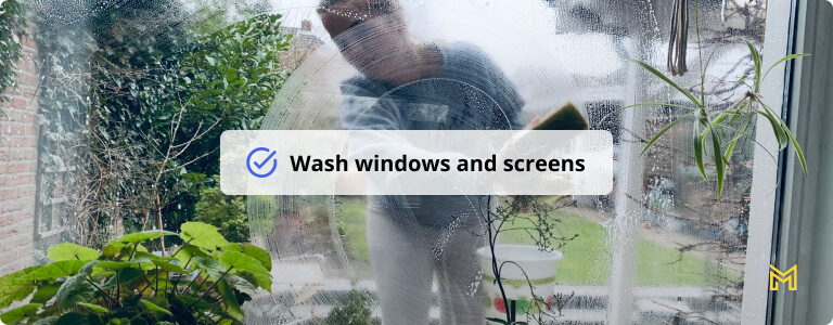 Young woman cleaning window