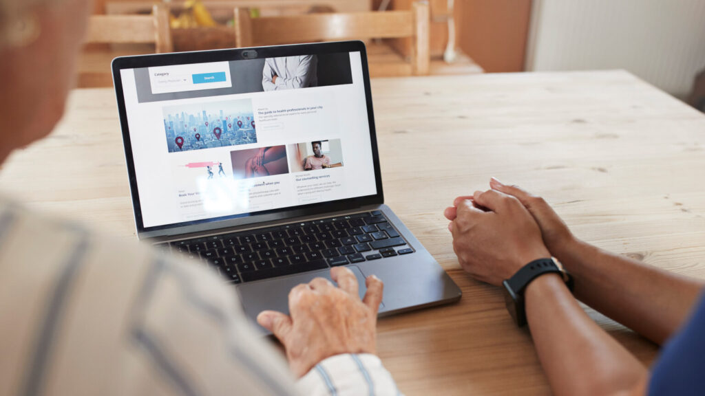 Cropped image of senior woman learning to book online appointment through laptop