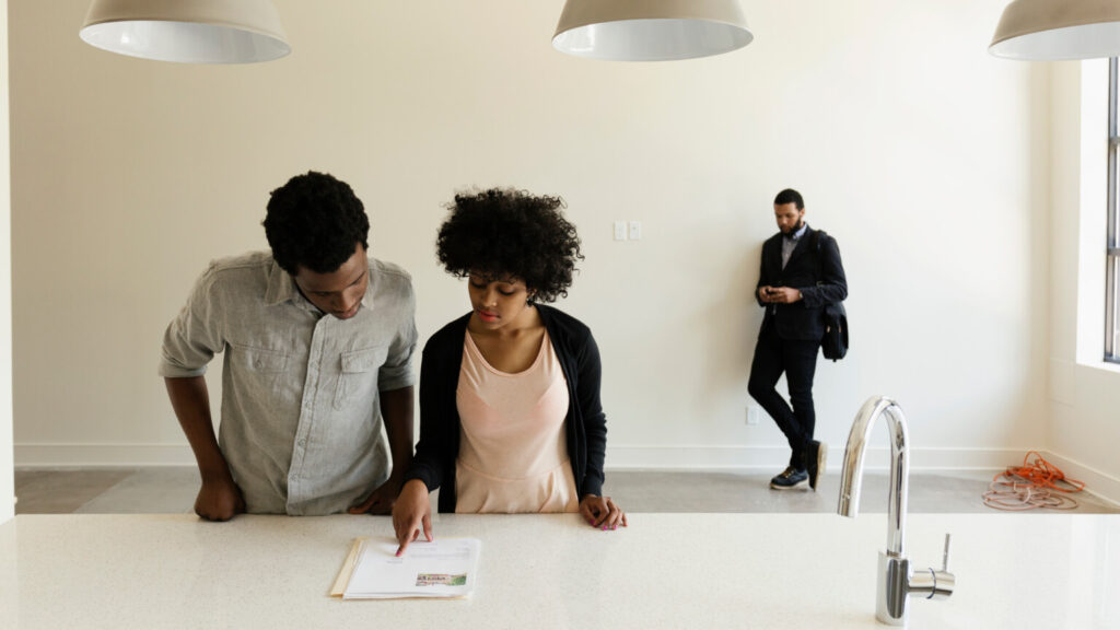 Couple reading paperwork in new house