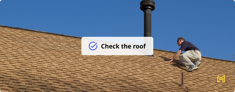 Home Inspector, on the roof, examines a roof gas vent.