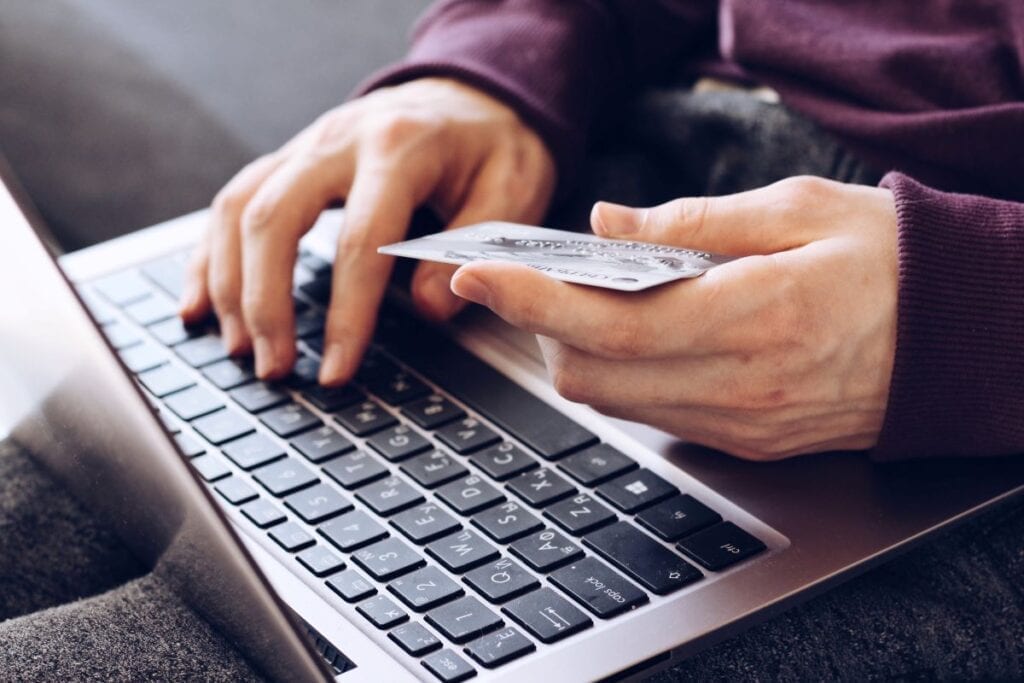 Person shopping online with credit card and laptop